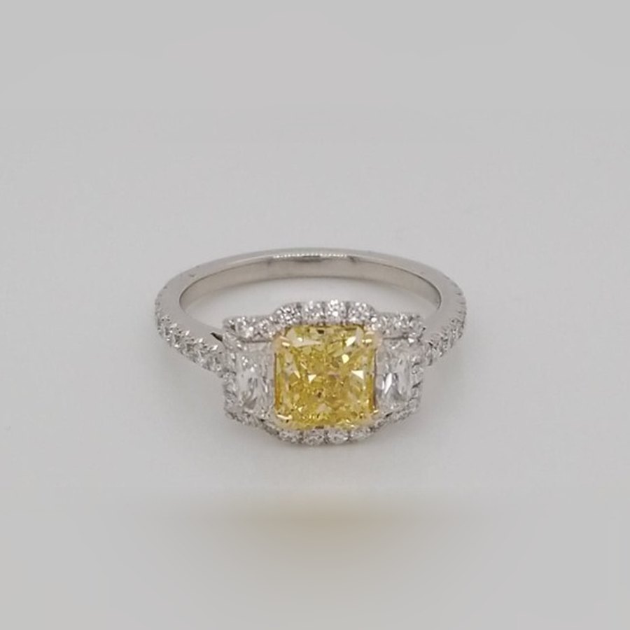 1.51 carat GIA fancy intense yellow radiant diamond engagement ring with trapezoid side stones and a diamond halo