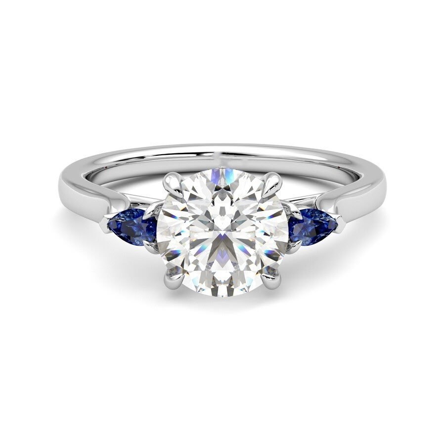 Round brilliant diamond engagement ring with pear-shaped blue sapphire accents in platinum