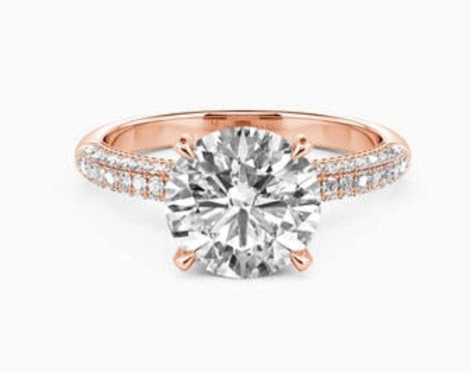 Round brilliant diamond engagement ring with a pavé-set band in rose gold