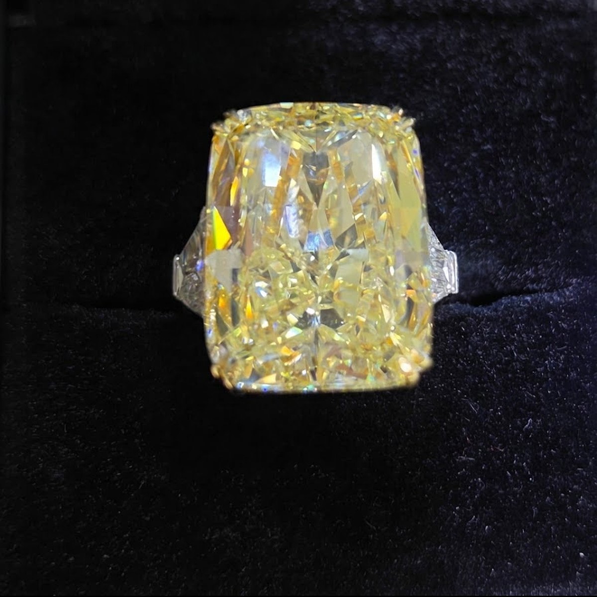 35.50 carat natural Fancy Intense Yellow cushion brilliant diamond ring with trapezoid side diamonds