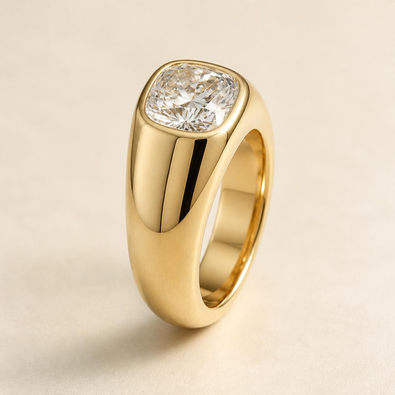 Cushion diamond flush-set in a wide polished yellow gold band